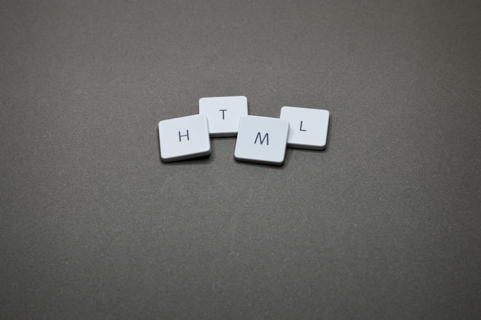 A person holding a small, white sticker featuring a blue, stylized atom symbol with intersecting elliptical orbits around a central circle. The individual's fingers are visible grasping the sticker at